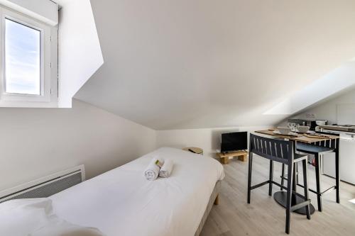 une chambre blanche avec un lit et un bureau dans l'établissement La scène - Wifi Université, à Angers