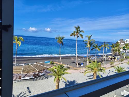 a view of a beach with palm trees and the ocean at Miramar Atlántico Playa in Los Llanos de Aridane
