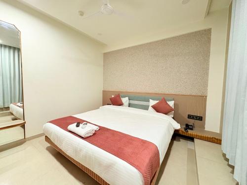 a bedroom with a large white bed with red pillows at Hotel city inn in Ahmedabad