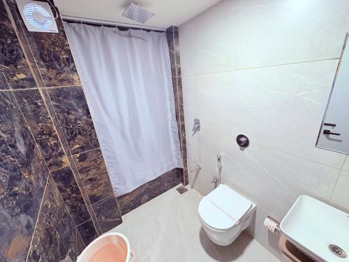 a bathroom with a shower and a toilet and a sink at Hotel city inn in Ahmedabad