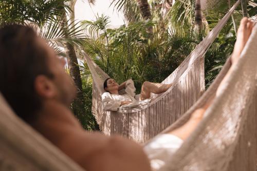 a woman laying in a hammock at Almare, a Luxury Collection Resort, Isla Mujeres, Adult All-Inclusive in Isla Mujeres