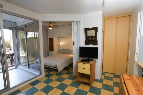 une chambre avec télévision et une chambre avec balcon dans l'établissement St Cyprien appartement proche plage, à Saint-Cyprien