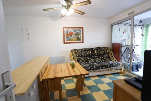 un salon avec une table et un canapé dans l'établissement St Cyprien appartement proche plage, à Saint-Cyprien