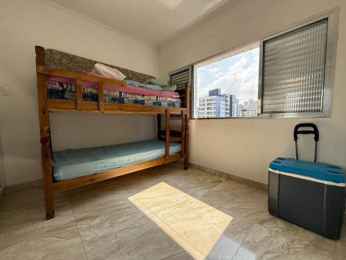 zwei Etagenbetten in einem Zimmer mit Fenster in der Unterkunft Apê vista mar pé na areia Guilhermina in Praia Grande