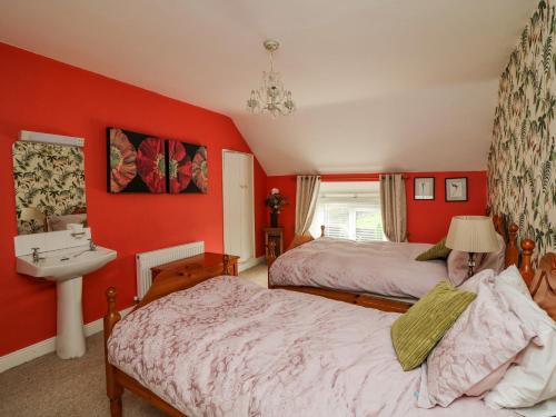 a red bedroom with two beds and a sink at The Dairy in New Ross