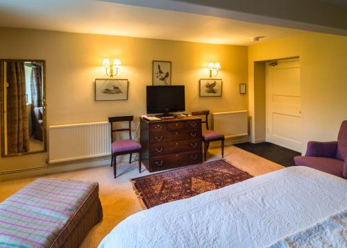 a bedroom with a bed and a tv and a couch at Greywalls Hotel & Chez Roux in Gullane