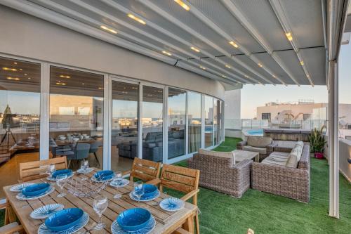 a patio with a table and chairs on a balcony at Beautiful Penthouse with pool and terrace in Is-Swieqi