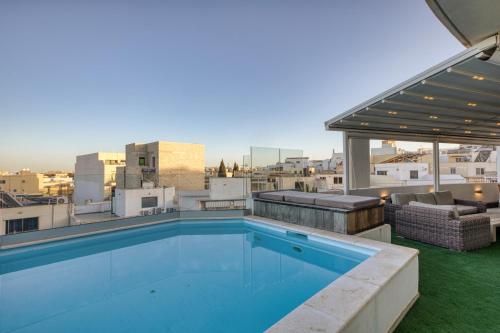 a swimming pool on the roof of a building at Beautiful Penthouse with pool and terrace in Is-Swieqi