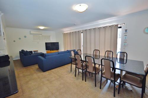 a living room with a table and chairs and a couch at Villa Palazzo 3 - Kalbarri, WA in Kalbarri