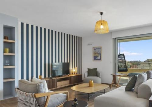 un salon avec un canapé et une télévision dans l'établissement Duplex Elegante Vista Panorâmica 360 Juan-les-Pins, à Antibes