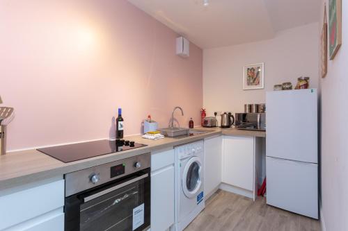 a kitchen with a washer and dryer and a refrigerator at Stravaig in Innerleithen