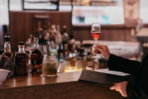 a person holding a glass of wine at a bar at Stammhaus im Hotel Alpine Palace in Saalbach Hinterglemm
