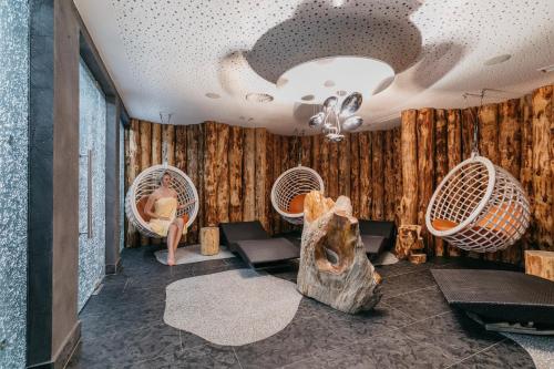 a room with two wicker chairs and a ceiling at Stammhaus im Hotel Alpine Palace in Saalbach Hinterglemm