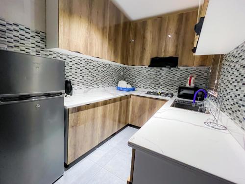 a kitchen with wooden cabinets and a stainless steel refrigerator at Box residence hotel and apartment in Lagos