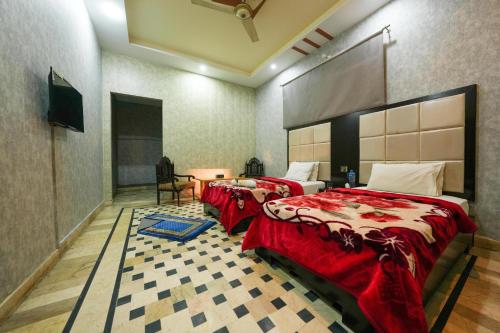 a bedroom with two beds and a tv in it at Hotel the Lodges inn in Multan
