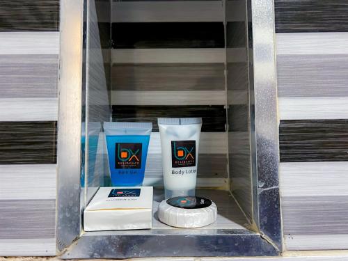 a glass shelf with two bottles ofodorizers and a wheel at Box residence hotel and apartment in Lagos