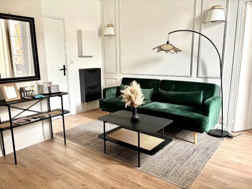 un salon avec un canapé vert et une table dans l'établissement Eleven Arene BY PRIMO C0NCIERGERIE, à Bourges