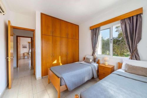 a bedroom with two beds and a window at The Arches Villa in Lachi