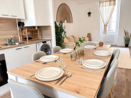 - une table en bois dans une cuisine avec salle à manger dans l'établissement Chaleureuse convivialité à partager, à Roanne
