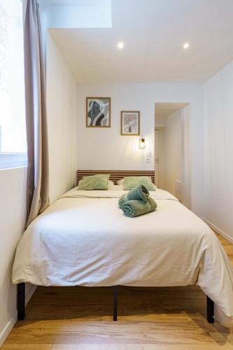 une chambre avec un grand lit blanc dans une pièce dans l'établissement Studio Détente 2 pers wifi gare, à Saint-Quentin