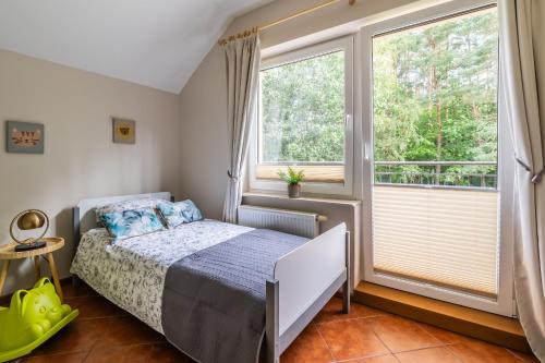 a bedroom with a bed and a large window at Willa Garian in Woryty