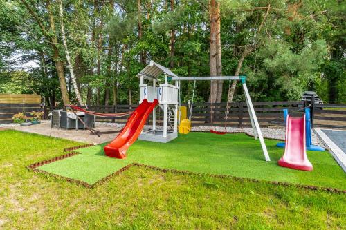 a playground with a slide and a swing at Willa Garian in Woryty