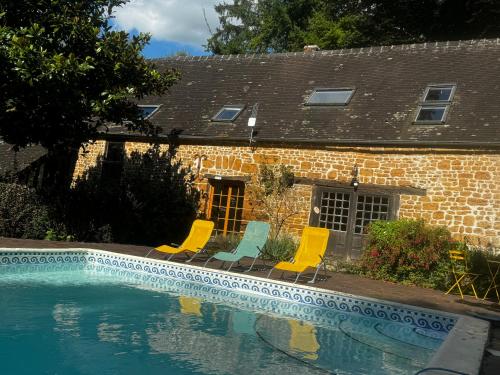 une piscine avec des chaises et une maison dans l'établissement Epicéas, piscine, tennis, lac, à Guerquesalles