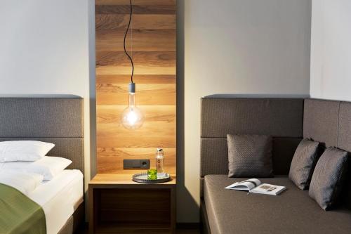 a bedroom with two beds and a table with a lamp at Stadthotel Brunner in Schladming