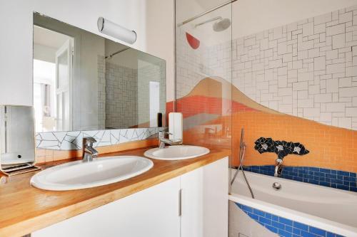 une salle de bain avec deux lavabos et un miroir dans l'établissement Moderne 3 pièces au coeur des Champs-Elysées, à Paris