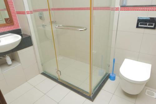 a bathroom with a shower with a toilet and a sink at Victorious Kings Homes in Mtwapa