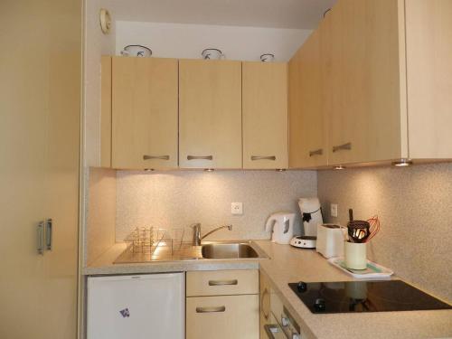 Elle comprend une petite cuisine avec des placards en bois et un évier. dans l'établissement Appartement 2 pièces 4 couchages à LA LONDE LES MAURES LAL150-094, à La Londe-les-Maures