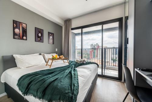 a bedroom with a bed and a large window at NK | Vila Mariana | Localização Perfeita in São Paulo