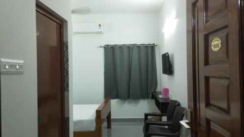 a room with a door and a green shower curtain at JK Residency in Virudunagar
