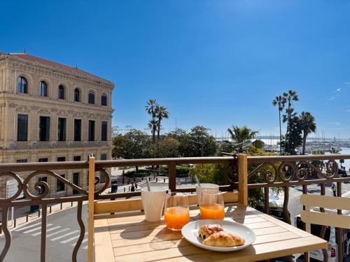 une table avec une assiette de nourriture sur un balcon dans l'établissement Cornut 4A, à Cannes