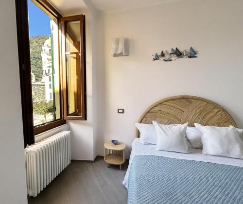 ein Schlafzimmer mit einem großen Bett und einem Fenster in der Unterkunft Ca der Duse in Vernazza