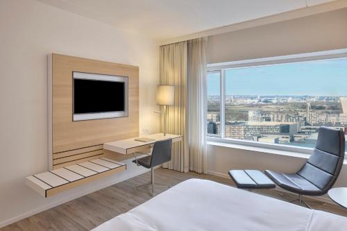 a hotel room with a bed and a desk and a television at Crowne Plaza Copenhagen Towers by IHG in Copenhagen