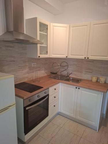 a kitchen with white cabinets and a sink at Apartments VESNA in Pag