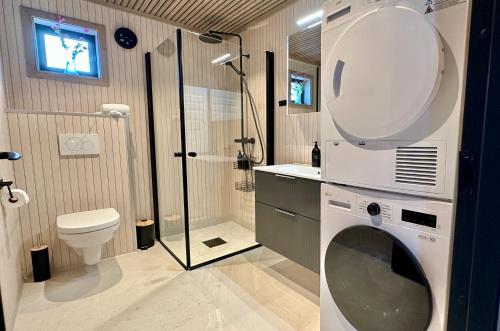 a bathroom with a shower and a toilet and a sink at Premium Chalet with Grand View in Sørvågen