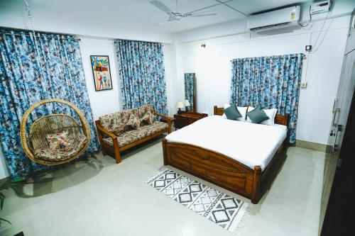 a bedroom with a bed and a couch and a chair at Nivasa Homestay - Khanapara Guwahati in Guwahati