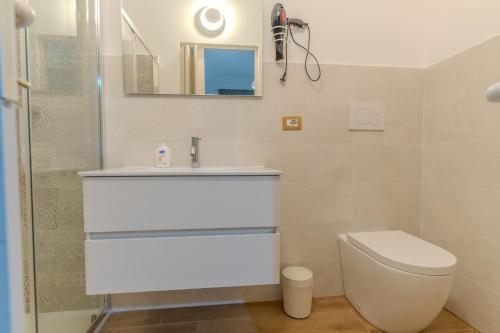 a bathroom with a toilet and a sink and a mirror at CasaBlanc in Santa Teresa di Riva
