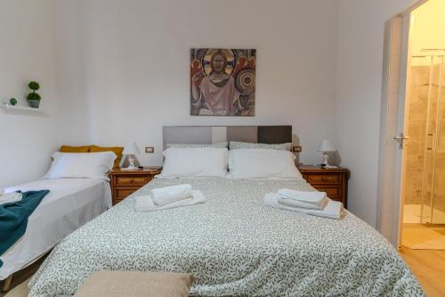 a bedroom with two beds and a painting on the wall at CasaBlanc in Santa Teresa di Riva