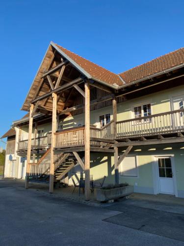 a building with a wooden deck on the side of it at Ferienwohnung Maier in Fürstenfeld