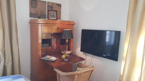 a living room with a television and a table with a lamp at Remise Heiliger See in Potsdam
