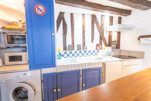 une cuisine avec un évier et une machine à laver dans l'établissement La Petite Hermine, à Amboise