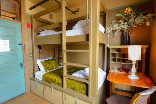 a room with bunk beds with a desk and a table at Michie Hostel in Providence