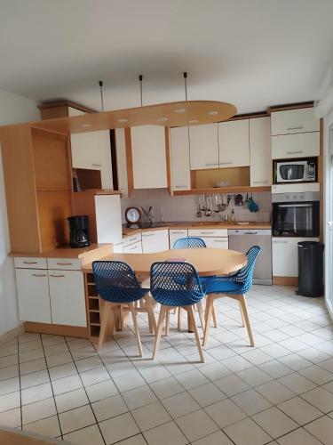 une cuisine avec une table et des chaises en bois dans l'établissement Maison proche de la mer, à Saint-Méloir-des-Ondes