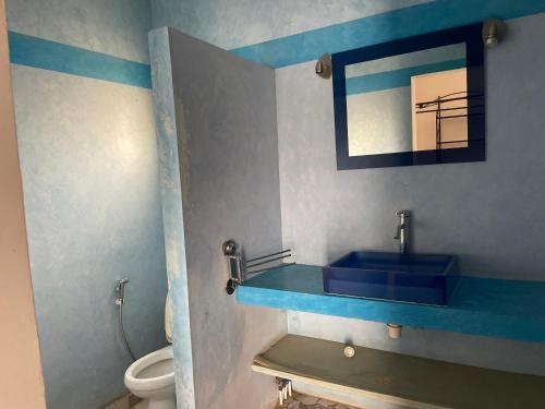 Un baño con un lavabo azul y un inodoro. en Villa Lydia Saly, en Saly Portudal