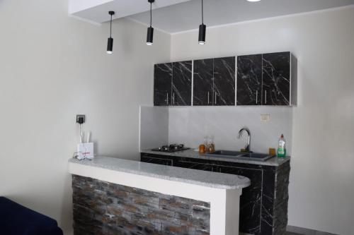 a kitchen with black and white marble countertops at Al Yasmine residence in Douz