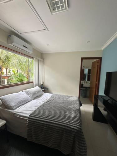 a bedroom with a bed and a large window at Casa Caborê, Paraty-RJ in Paraty
