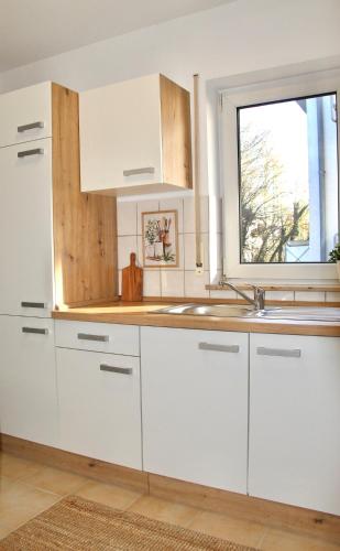 a white kitchen with a sink and a window at DEM Apartment in Bad Schonborn